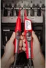 Two hands holding electrical testing tools in front of an electrical panel. Voir les images du produit