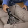 A person is cleaning a stained couch with a vacuum cleaner attachment. Anteprima dell’immagine prodotto