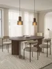 A dining room scene with an oval wooden dining table and chairs, illuminated by pendant lights. Produktbild-Vorschau