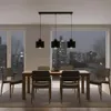 A dining room with a table and chairs, illuminated by a modern pendant light fixture. Náhled obrázku produktu