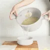 A person is draining pasta from a pot into a bowl. Produktbild-Vorschau