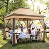 A group of people are gathered around a table under a tan and brown gazebo in a garden setting. Produktbild-Vorschau