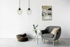 A living room scene with a chair, a small table, a pouf, and two pendant lights. Náhled obrázku produktu