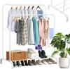 A double-tiered metal clothing rack filled with clothes and shoes, with a basket and a plant. Podgląd zdjęcia produktu