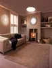 A cozy living room with a sofa, fireplace, and a large rug. Produktbild-Vorschau