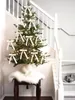 A Christmas tree decorated with bows and lights is placed on a staircase landing. Voir les images du produit