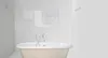 A clean, minimalist bathroom with a freestanding bathtub and towels hanging on a line. Náhled obrázku produktu