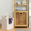 A laundry basket and a bamboo shelving unit in a room. Produktbild-Vorschau