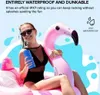 A woman is sitting on a pink inflatable flamingo in a pool, holding a blue speaker. Náhled obrázku produktu