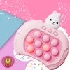 A pink electronic toy with a rabbit design, featuring pop-it bubbles and musical notes in the background. Produktbild-Vorschau