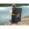A woman carrying a black bag with yellow accents on her back near a body of water. Náhľad obrázku produktu