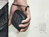 A hand holding a battery charger with AA batteries inside, next to a diagram of the charger with dimensions. Produktbild-Vorschau