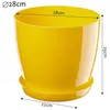 A yellow plastic plant pot with a saucer, with dimensions indicated by text and lines. Podgląd zdjęcia produktu