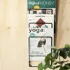 A magazine rack mounted on a wooden wall, filled with magazines. Produktbild-Vorschau