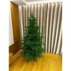 A green artificial Christmas tree stands on a wooden floor in front of beige curtains. Podgląd zdjęcia produktu