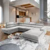 A modern living room with a large sectional sofa, coffee tables, and a kitchen area in the background. Produktbild-Vorschau