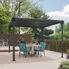 A couple sits at a table under a pergola on a wooden deck. Podgląd zdjęcia produktu