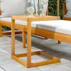 A wooden C-table placed on a tiled patio next to a lounge chair with white cushions. Náhled obrázku produktu