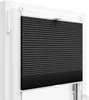 A close-up view of a black pleated blind installed in a white window frame. Produktbild-Vorschau