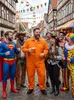 A group of people in costumes are posing for a photo on a street decorated for a festival. Produktbild-Vorschau