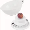 A white mechanical kitchen scale with a white bowl and a red apple on top. Voir les images du produit