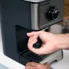 A person's hands are operating a coffee machine. Produktbild-Vorschau