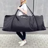 A woman is carrying a large black bag over her shoulder. Produktbild-Vorschau