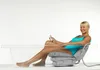 A woman is sitting in a bathtub using a bathing cushion. Produktbild-Vorschau
