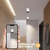 A hallway with modern lighting and furniture, featuring a smartphone displaying a light fixture. Produktbild-Vorschau