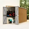 An open garden shed with tools and storage boxes inside, set against a wall and foliage. Náhled obrázku produktu