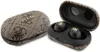 A pair of black wireless earbuds with gold logos, shown inside an open brown charging case with a Guess logo pattern. Produktbild-Vorschau
