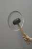 A hand holding a rubber mallet is about to strike a circular opening in a gray surface. Anteprima dell’immagine prodotto