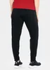 A person wearing black polyester pants and a red shirt, viewed from the back. Produktbild-Vorschau