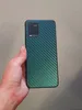 A hand holds a smartphone with a carbon fiber-like skin on the back. Produktbild-Vorschau
