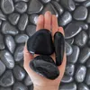 Schwarze polierte Kieselsteine auf einer Handfläche zur Größendarstellung Produktbild-Vorschau