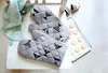 Oven mitts with a fish pattern are laid out on a white surface next to a baking sheet with cookies and a folded cloth. Anteprima dell’immagine prodotto