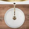 A top-down view of a white marble sink with a gold faucet. Produktbild-Vorschau