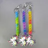 Three rainbow-colored unicorn keychains are displayed against a plain gray background. Produktbild-Vorschau