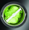 Top-down view of an ice cream maker with green ice cream and a mixing paddle. Produktbild-Vorschau