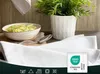 A close-up shot of white kitchen towels with a bowl of pasta and a plant in the background. Produktbild-Vorschau