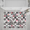 A black and white playmat with red accents is laid out on a light gray wooden floor next to a white crib. Náhľad obrázku produktu