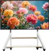 A white TV stand with two shelves and wheels, displaying a colorful floral image on its screen. Podgląd zdjęcia produktu