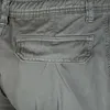 A close-up view of the pocket and waistband of a pair of gray cargo jogging pants. Produktbild-Vorschau
