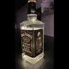 A Jack Daniel's whiskey bottle with LED lights inside, placed on a dark surface. Anteprima dell’immagine prodotto