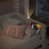 A bed with pillows and a tablet charging on the headboard. Náhled obrázku produktu