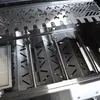 Close-up view of the interior of a grill, showing heat reflectors and burners. Produktbild-Vorschau