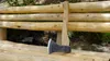 An axe rests on a wooden bench in an outdoor setting. Anteprima dell’immagine prodotto