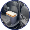 A portable cooler is placed on the floor of a car between the front and back seats. Produktbild-Vorschau