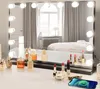 A vanity mirror with lights is set up on a dresser, reflecting a bedroom scene. Various makeup products are arranged on the dresser in front of the mirror. Produktbild-Vorschau