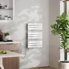 A modern bathroom or kitchen setting with a white electric towel warmer mounted on a textured gray wall. Anteprima dell’immagine prodotto